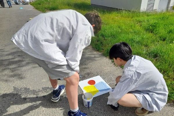 Studenti plzeňské Sutnarky pomáhají dětem v Praze. Barevné chodníky mají omezit kolony u školy